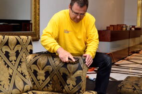 Mitarbeiter reinigt gründlich ein Sofa in einem Hotel