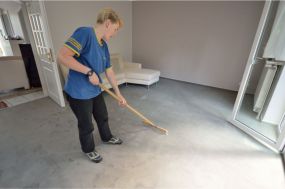 Mitarbeiterin stellt Flor des gereingten Teppichbodens auf
