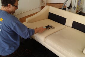 Mitarbeiter reinigt Alcantara Sofa