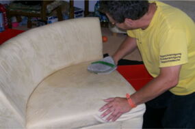 Mitarbeiter schamponiert Polster von Hand